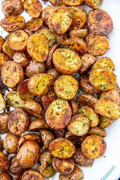 roasted potatoes on a white plate with seasoning sprinkled around the top and side