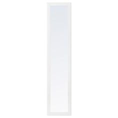 a tall white mirror sitting on top of a wall