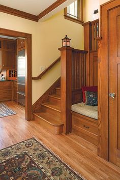 an entryway with wooden stairs and wood paneling, along with a rug on the floor