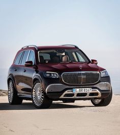 the front end of a red mercedes gls parked on top of a dirt hill