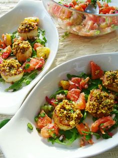 two white bowls filled with food on top of a table