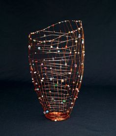 a glass vase with lights on it sitting on a black surface