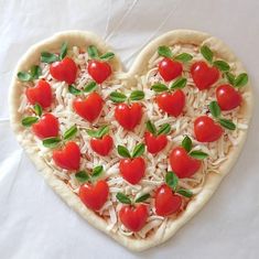 a heart shaped pizza topped with tomatoes and cheese