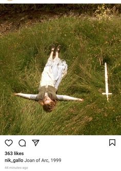 a person laying in the grass with their arms spread out