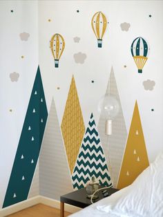 a bedroom decorated with colorful wallpaper and hot air balloons