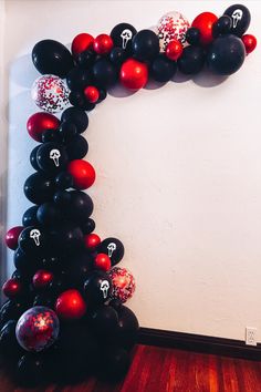 the balloon arch is decorated with black, red and white balloons