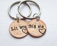 two personalized penny key chains with the words, lil bro big sis on them