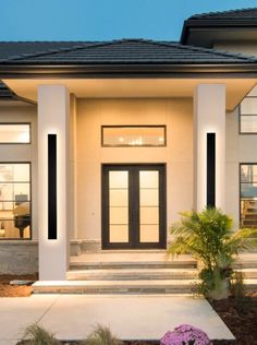 the front entrance to a modern home at night