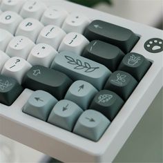 a close up of a computer keyboard with leaves on the keys and an arrow sticker