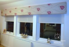 a window with pink hearts on the valance and matching blinds in front of it