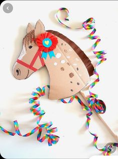 a paper horse with a red bow on it's head is surrounded by streamers