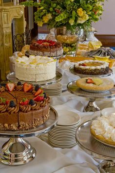 a table topped with lots of cakes and desserts