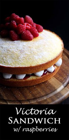 a cake with raspberries on top and the words victoria sandwich w / raspberries