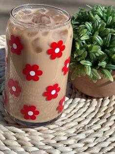 a drink sitting on top of a wicker table next to a potted plant