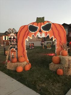 an outdoor halloween decoration with pumpkins and hay