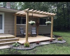 a wooden patio with steps leading up to the front door and sitting area on the side of the house