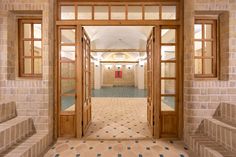 an open door leading to another room with tiled flooring and stone steps on either side