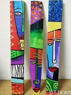 three pieces of art made out of wood and painted with different colors, shapes and sizes