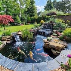 an outdoor pond surrounded by rocks and water features fish swimming in it, along with other plants and trees