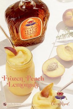 a bottle of peach lemonade sitting next to sliced peaches on a white table