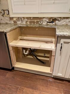 an open cabinet in the middle of a kitchen