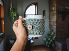 a person holding a coffee cup with a button on it