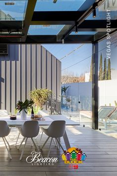 an outdoor dining area with white chairs and table