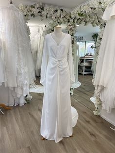 a white wedding dress on display in a bridal room