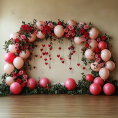 the balloon arch is decorated with roses and hearts