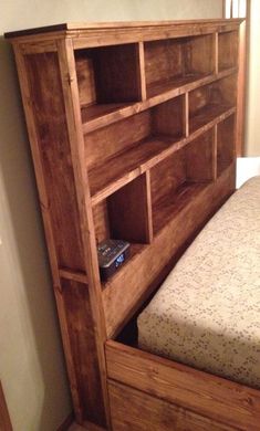 a wooden book shelf next to a bed