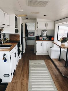 a kitchen with white cabinets and wood floors