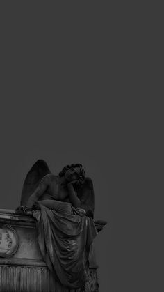 an angel statue on top of a building with a clock in the backround