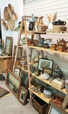 there are many items on the shelves in this room, including pictures and baskets hanging from them