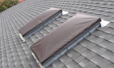 the roof is covered with brown tarp for protection from wind and rain as it sits in front of pink flowers