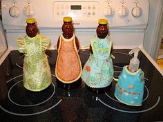 four bottles are sitting on top of an oven with soap and pepper shakers in them