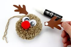 someone is making a reindeer ornament out of yarn and felt with glue on it