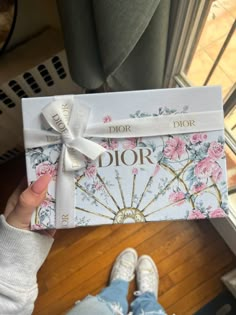 a person holding up a dior gift box