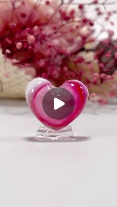 a heart shaped glass object sitting on top of a table