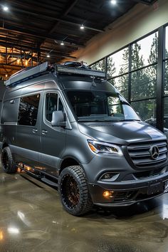 a mercedes van is parked in front of large windows