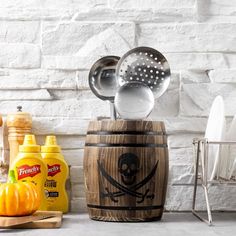 a wooden barrel filled with cooking utensils on top of a counter next to other kitchen items