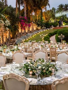 an outdoor dining area with tables and chairs set up for formal function in the evening