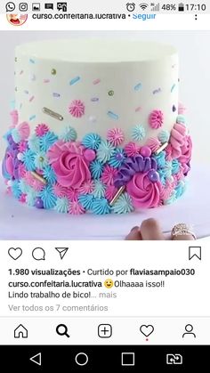 a white cake with pink and blue flowers on it