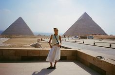 a woman standing in front of two pyramids