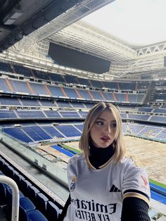 a woman standing in front of an empty stadium