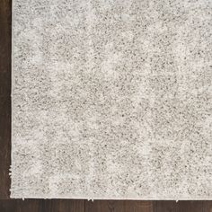 a white rug on top of a wooden floor