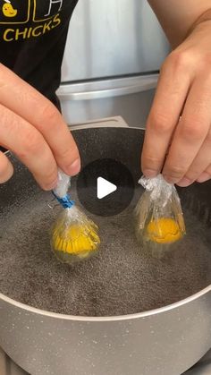 someone is cooking something in a pan with plastic bags on the handle and yellow handles