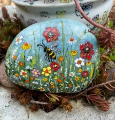 a painted rock sitting on top of some grass