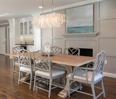 a dining room table with six chairs and a chandelier hanging from the ceiling