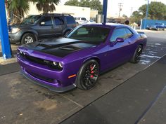 a purple and black car is parked on the street