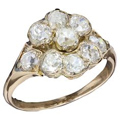 an antique diamond cluster ring in yellow gold, set with old cut diamonds and surrounded by smaller round brilliant stones